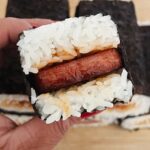 cooked spam in sauce with rice on both sides wrapped with nori sheets to make a spam musubi.